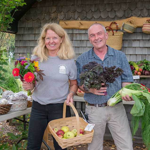 blond woman and man holding produce 