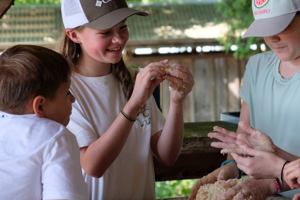 Children make dough in outdoor kitchen at Shelburne Farms