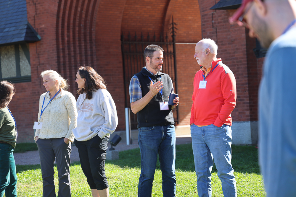 People in conversation outside of a large brick building
