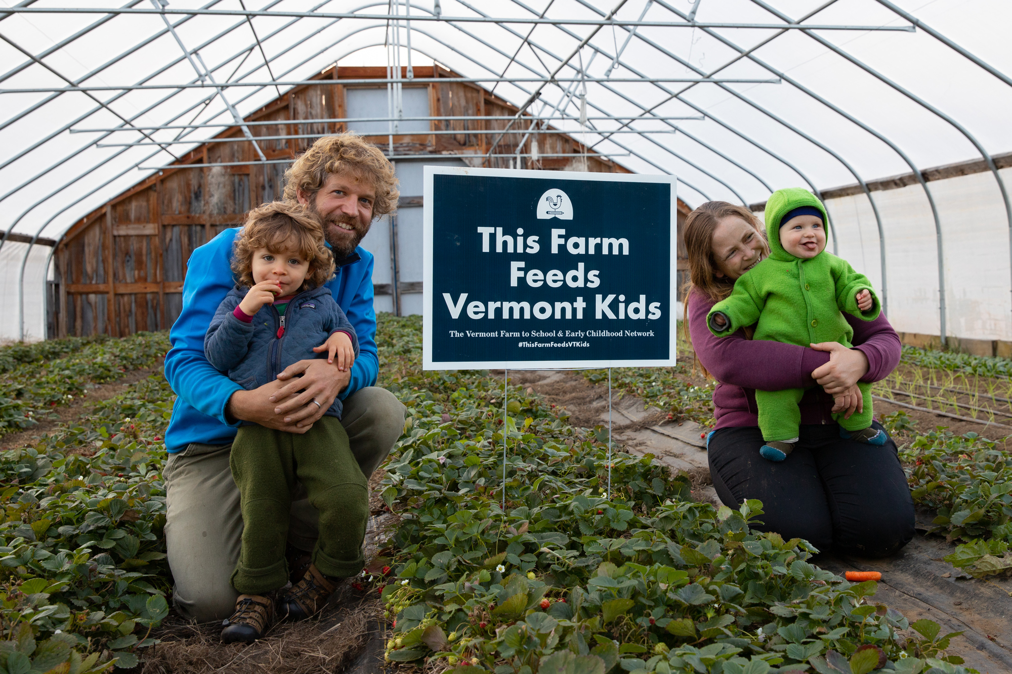The Paradee Family of Long Winter Farm (Stowe, VT) proudly displays a "This Farm Feeds Vermont Kids" lawn sign in a hoop house.