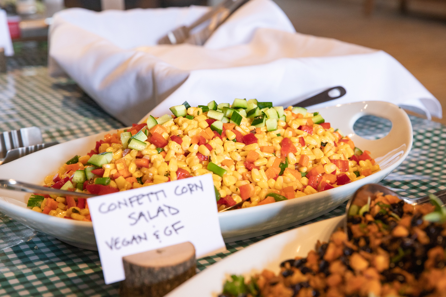 A serving bowl of Confetti Corn Salad on a buffet line.