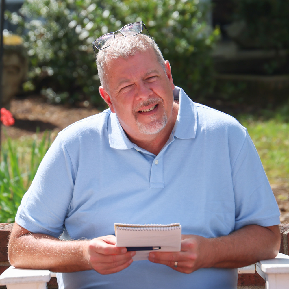 Brent sitting outdoors engaged in a group discussion