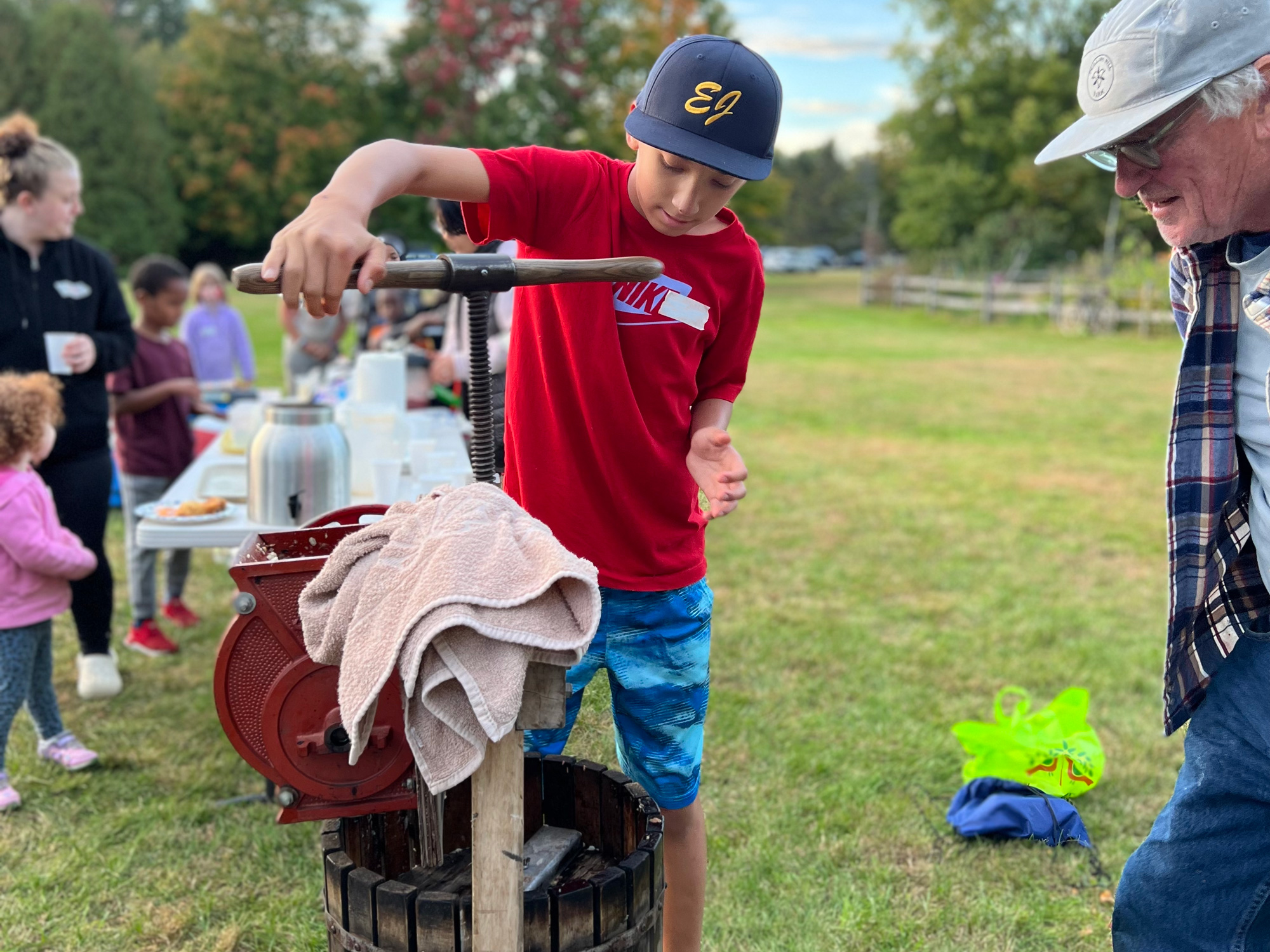 A child uses a cider press