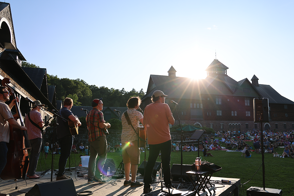 band performing to audience on Farm Barn courtyard lawn