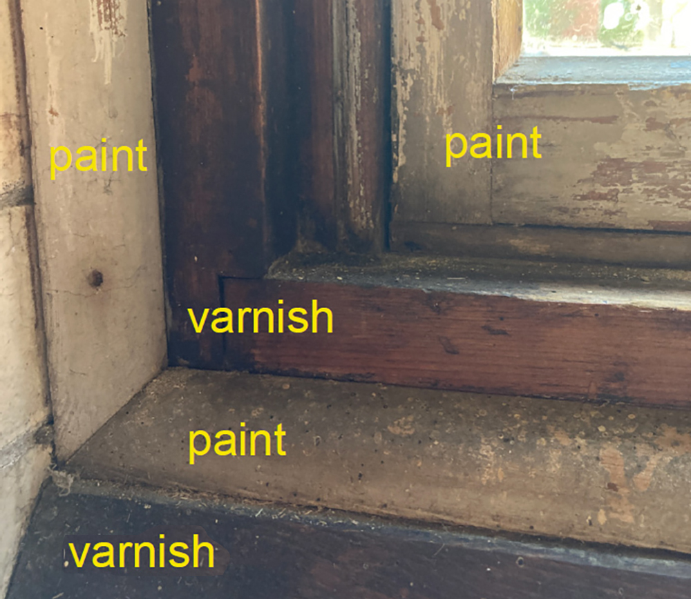 corner trim of a window close up with words indicating what is painted or varnished wood.