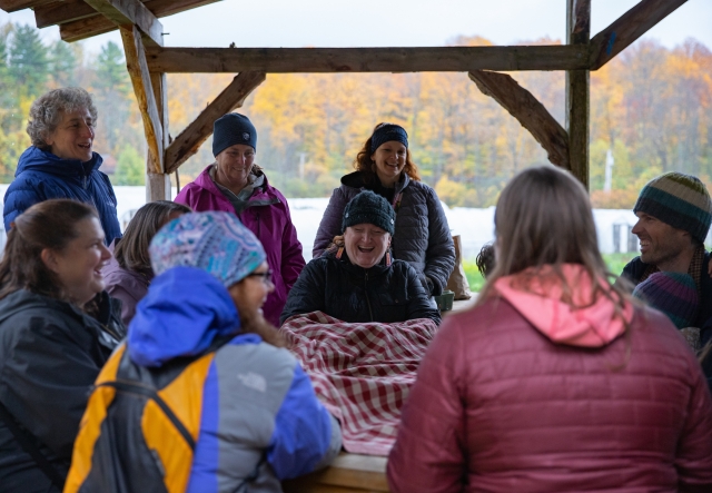 A group sits at a picnic table engaged in an activity
