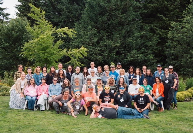 A large group of farm to school practitioners gather for an outdoor group photo