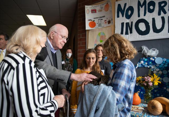 Senator Patrick Leahy and Marcelle Pomerleau Leahy talk with Crossett Brook Middle School students during the Farm to School Project Share. Here they speak with students from the sustainability club and meet Molly the hen, part of the school's flock of chickens.