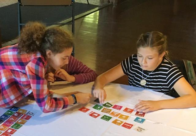 Two children working on a project with colorful paper