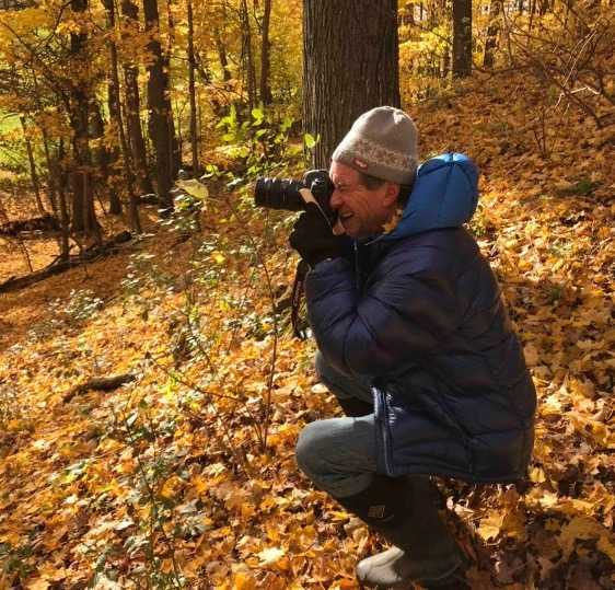 Marshall Webb taking a photo in the woods