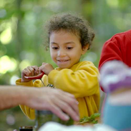 A child pulls the cord on a manual food chopper.