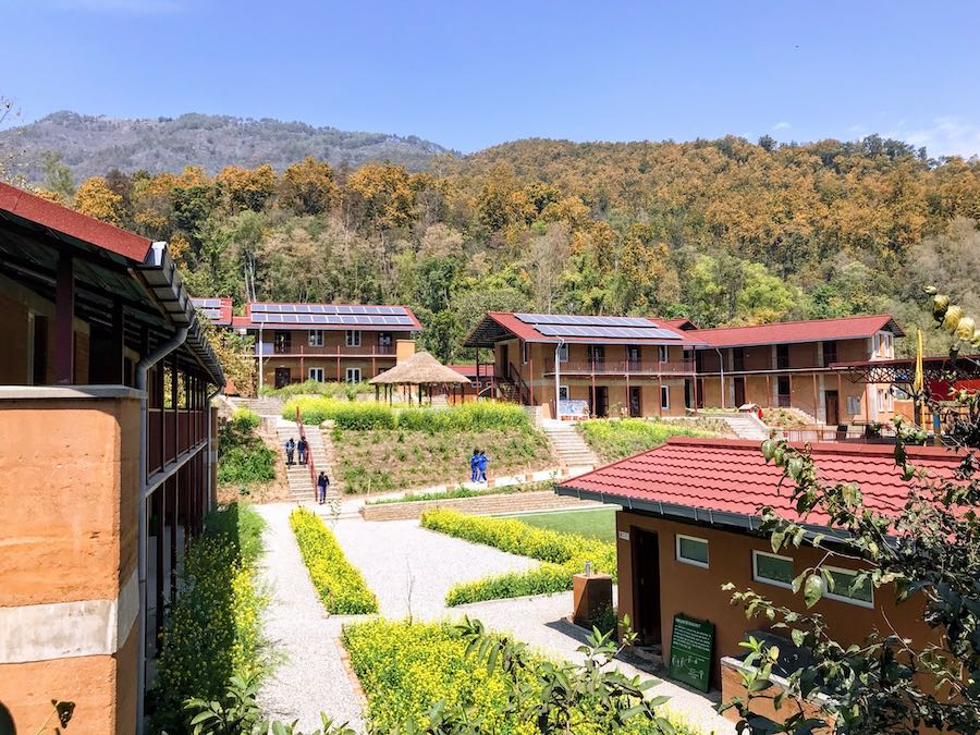 Kopila Valley School campus seen from a second story view. The campus is sprawling and set amongst rolling green hills.