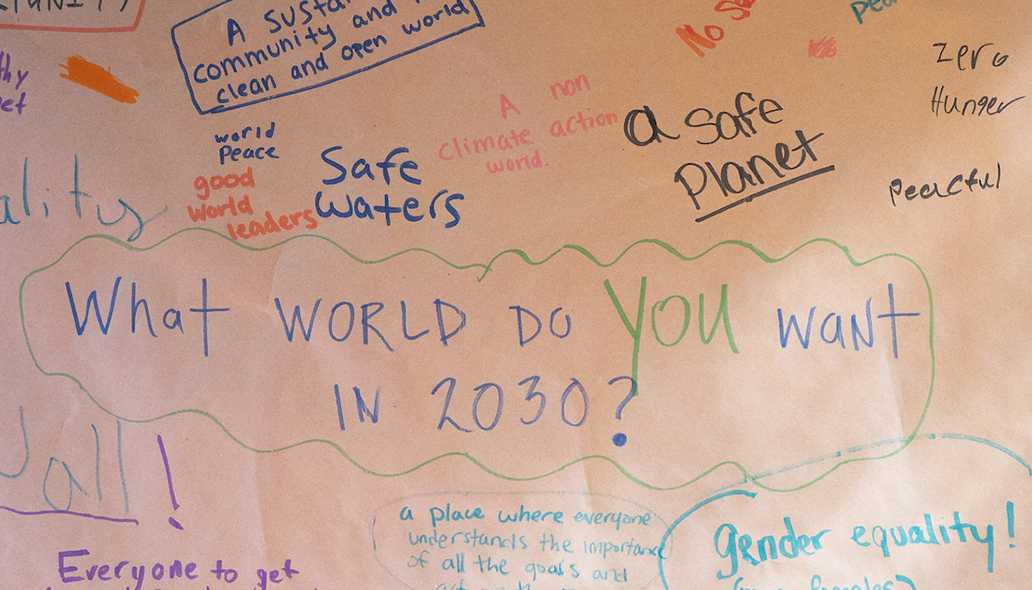 Handwritten responses on a large sheet of paper to the question what kind of world do you want to see in 2030