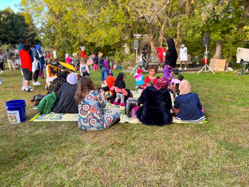 families sit on picnic blankets at an outdoor fall event