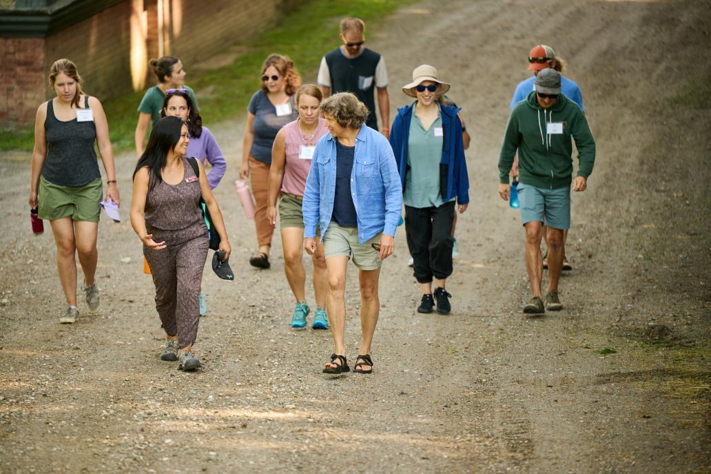 Educators walk down a trail outdoors.