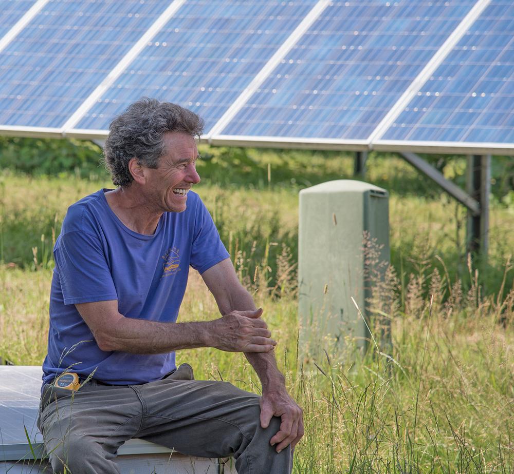 Marshall Webb sitting in front of solar panels