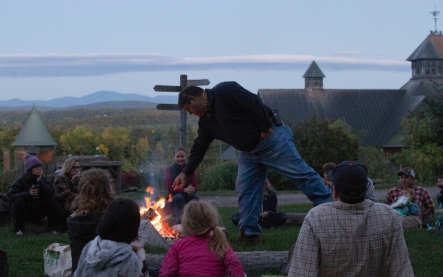 Chief Don Stevens feeds a fire during a Shelburne Farms campfire family program.
