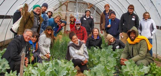 FBEN Members gather in a hoop house, greens growing all around.