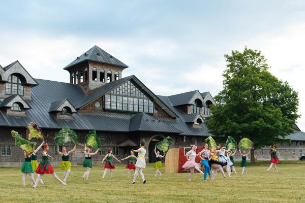 Dancers dancing on lawn in front of Breeding Barn