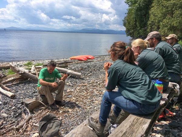 Marshall Webb teaching students along shore of Lake Champlain