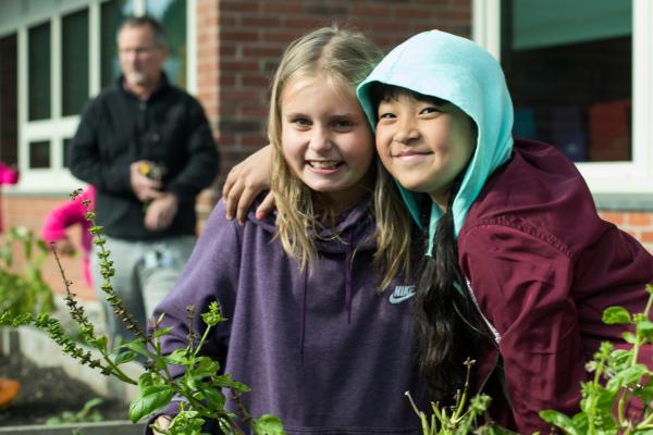 Two students harvest basil from a school garden in Burlington, Vermont.