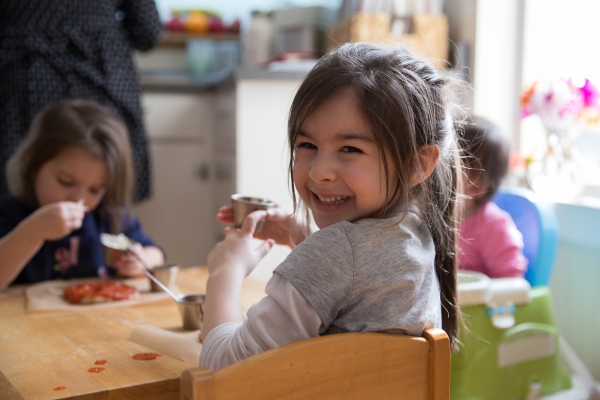 Photos by Sarah Webb Three young children sit around a table at a childcare center