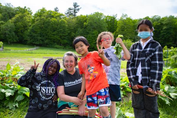 Students and a Shelburne Farms instructor smile in a green summer garden