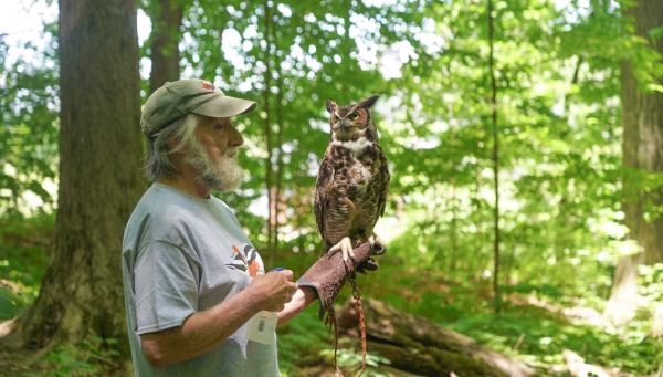 Man with a great horned owl perched on his arm.