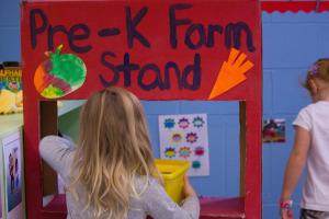 A toy reads, PreK Farm Stand, in a classroom