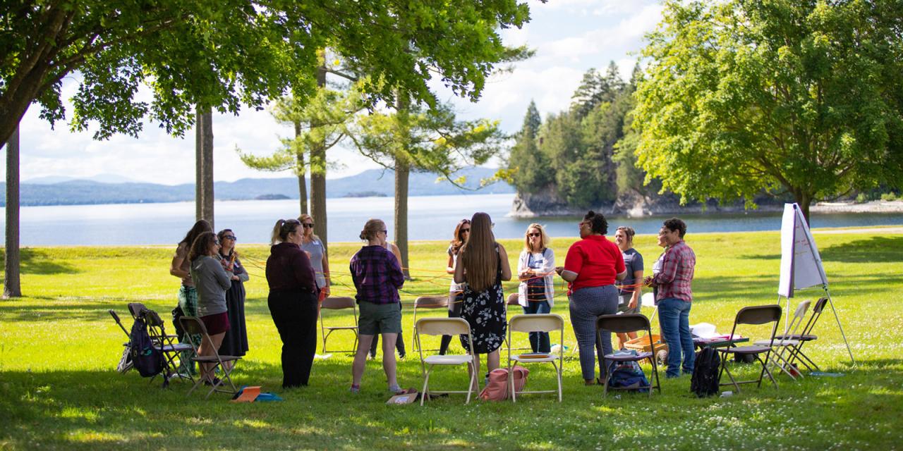 Educators gathered on the Coach Barn lawn, Lake Champlain in the background.