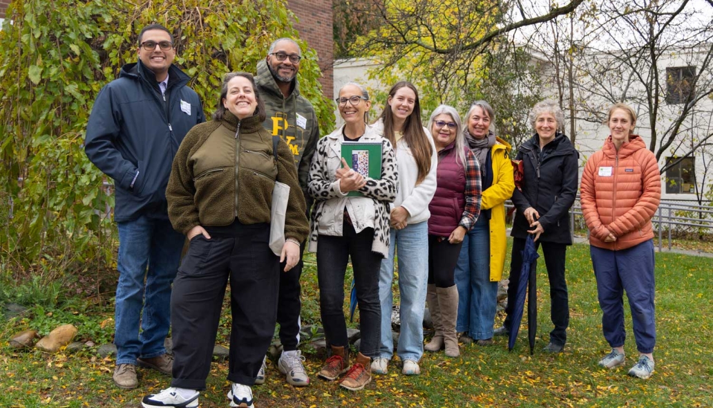 A group of people gather in front of a school.