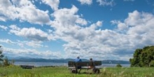 Visitors on a bench on top of Lone Tree Hill with a lake view