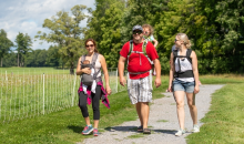 Visitors walking on a path next to a fence