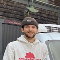 Manny Bowman in white hooded sweatshirt, brown hat, and beard