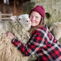 Shelburne Farms educator hugging a sheep