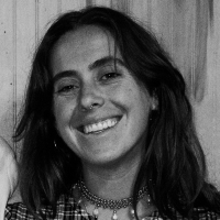 Black and white photo of woman with long dark hair smiling at camera.